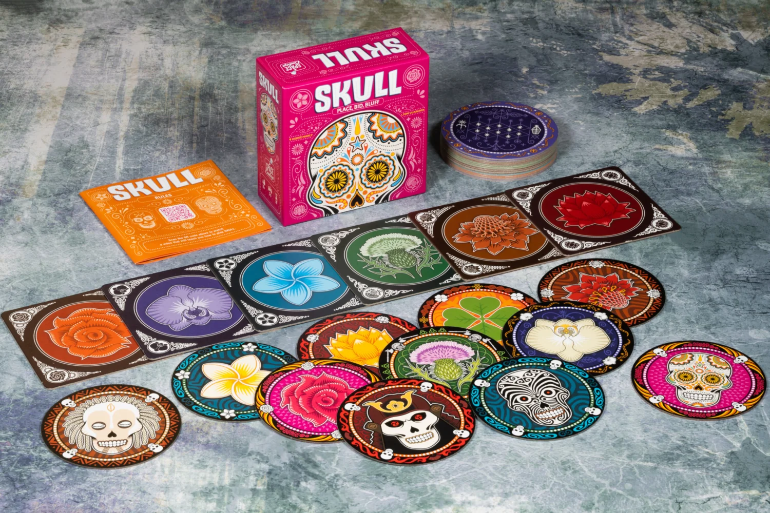 Componentes del juego Skull: discos de flores y calavera sobre la mesa